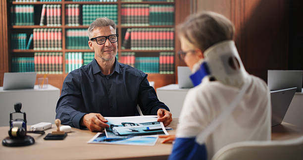 Experienced attorney reviewing accident case photographs with an injured patient wearing a cervical collar